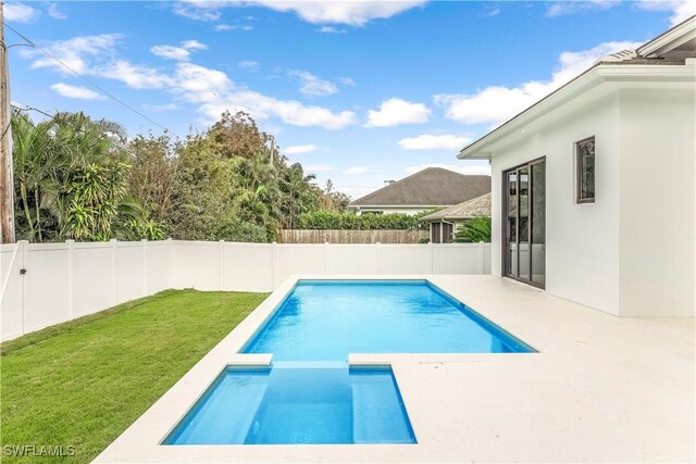 view of pool with a patio and a lawn