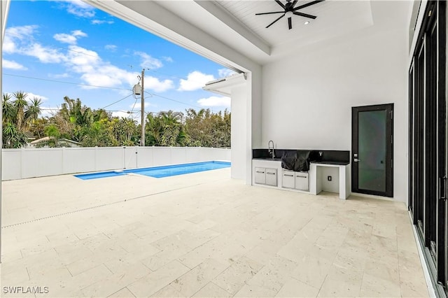 view of pool featuring an outdoor kitchen, ceiling fan, and a patio area