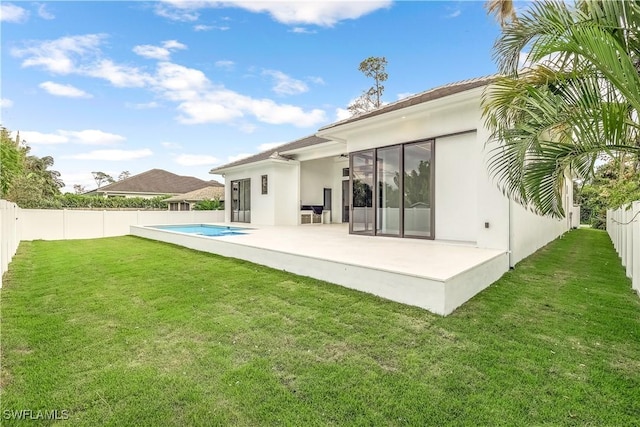 back of property featuring a yard, a fenced in pool, and a patio