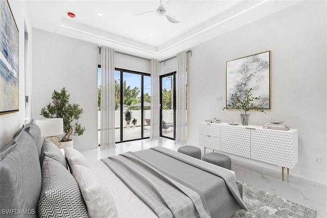 bedroom featuring access to exterior, ceiling fan, and a tray ceiling