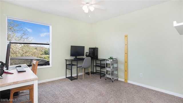 carpeted office space featuring ceiling fan and baseboards