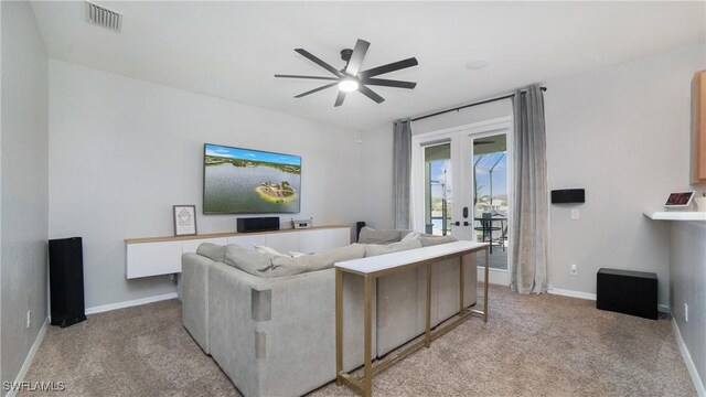 living room featuring light carpet, french doors, and ceiling fan