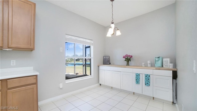 interior space with light tile patterned flooring, baseboards, and an inviting chandelier