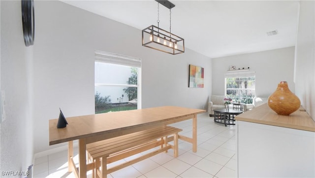 dining space with visible vents, a notable chandelier, and light tile patterned flooring