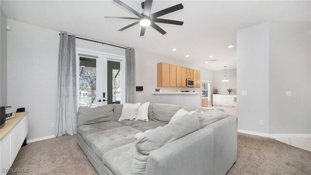 living room with light carpet, french doors, and ceiling fan