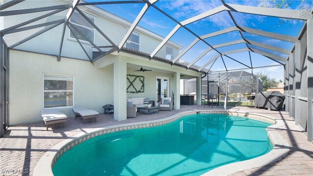 view of swimming pool featuring glass enclosure, french doors, an outdoor hangout area, ceiling fan, and a patio area