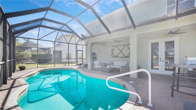 view of pool featuring outdoor lounge area, a lanai, a patio, and french doors