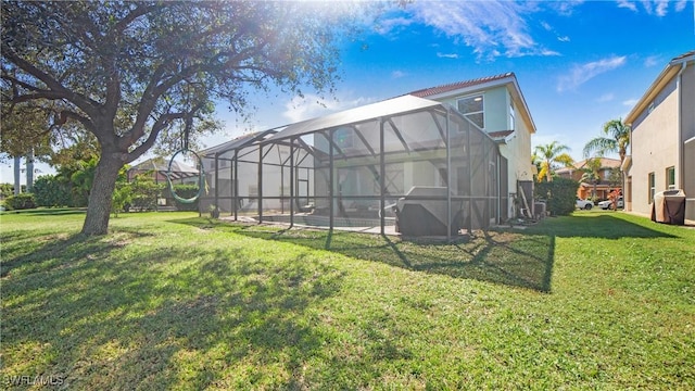 rear view of property with glass enclosure, a yard, and an outdoor pool