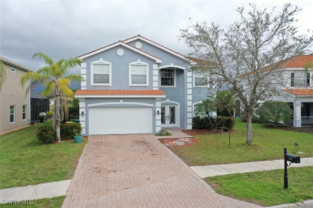 view of front facade featuring decorative driveway, stucco siding, a garage, a tiled roof, and a front lawn