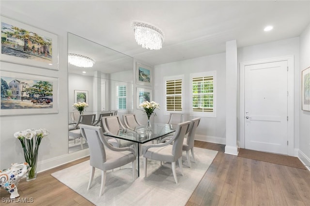 dining area with hardwood / wood-style floors and a chandelier