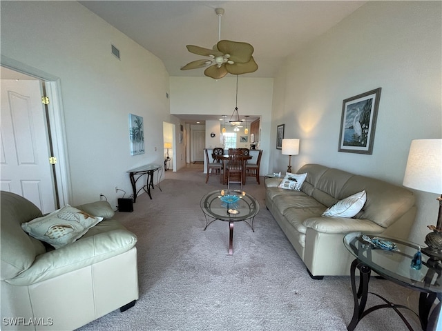 living room with ceiling fan, high vaulted ceiling, and light carpet