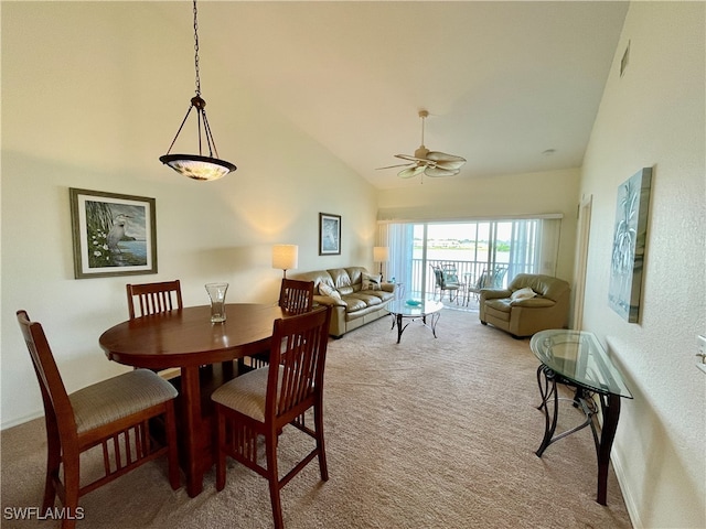 dining area with high vaulted ceiling, light colored carpet, and ceiling fan