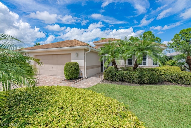 mediterranean / spanish-style home featuring a front yard and a garage