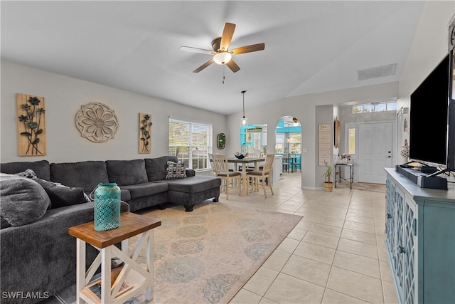 tiled living room featuring ceiling fan and vaulted ceiling