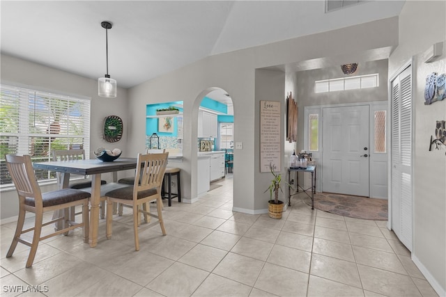 tiled dining space featuring lofted ceiling