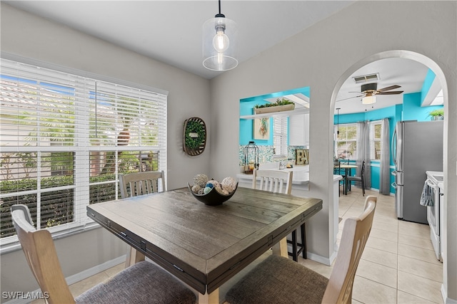 tiled dining room with ceiling fan and a wealth of natural light