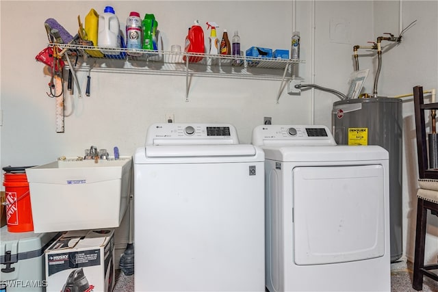 clothes washing area featuring carpet floors, water heater, sink, and washer and clothes dryer