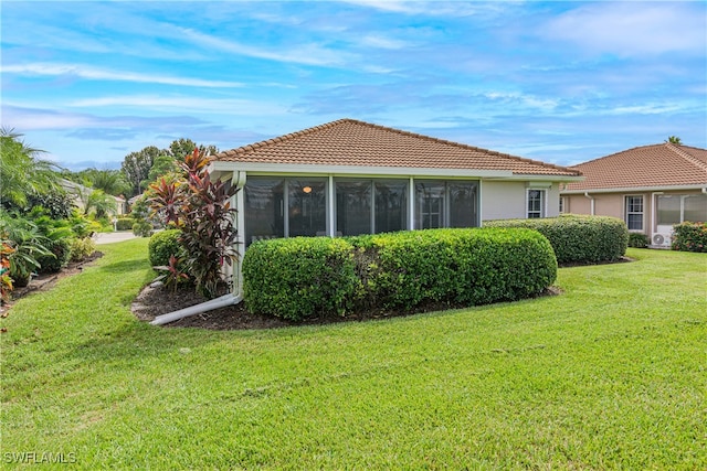 view of property exterior featuring a sunroom and a yard