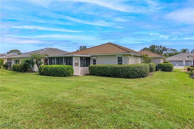 view of front of property featuring a garage, a front yard, and a sunroom