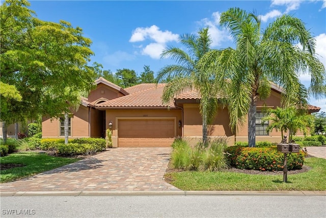 11077 Esteban Dr, Fort Myers, FL 33912 - view of front of home with an attached garage, a tiled roof, stucco siding, and driveway