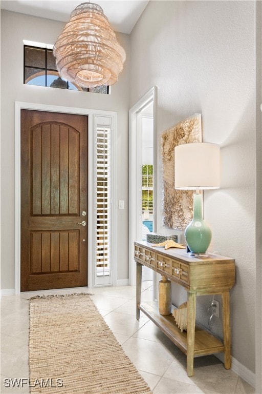 foyer with a chandelier and light tile patterned floors