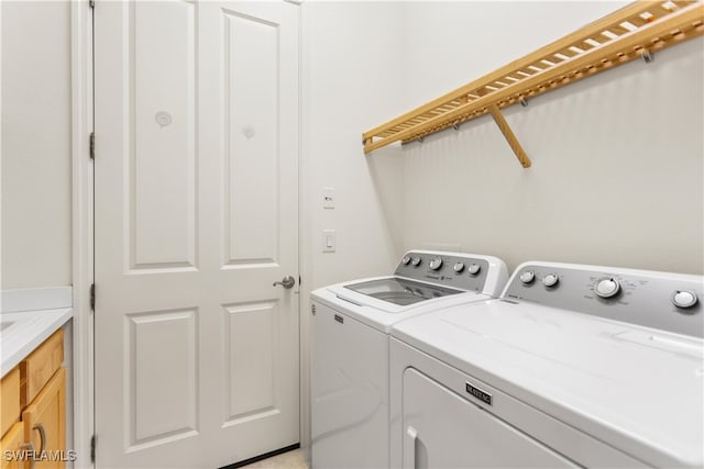 washroom with cabinets and washer and clothes dryer