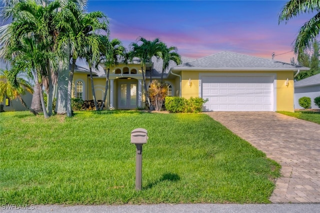 view of front of house with a garage and a lawn