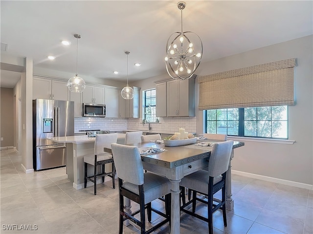 tiled dining space featuring an inviting chandelier and sink