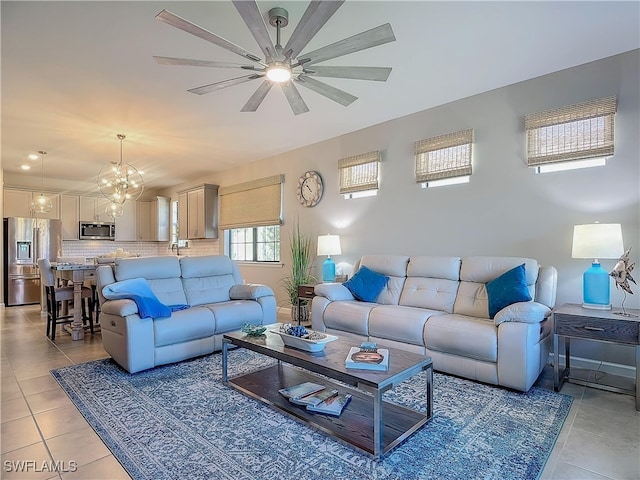 living room with ceiling fan with notable chandelier and light tile patterned flooring