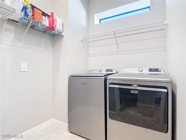 washroom with light tile patterned flooring and washer and dryer