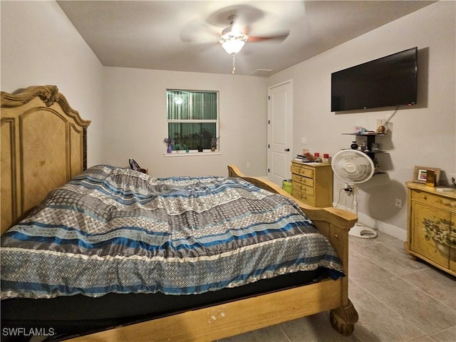 bedroom featuring light tile patterned floors, baseboards, and a ceiling fan