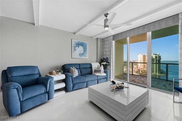 tiled living room with ceiling fan, beam ceiling, and a water view