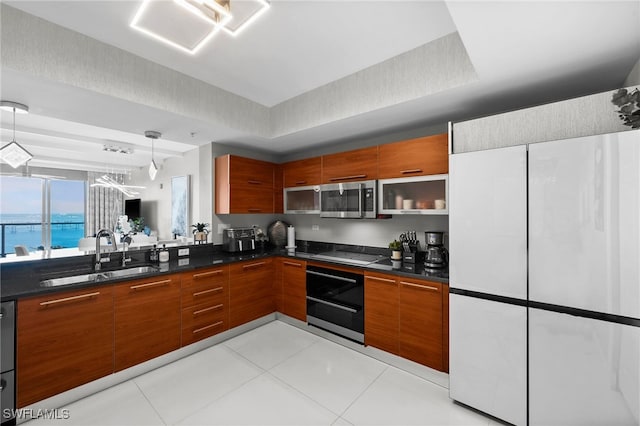 kitchen with light tile patterned floors, decorative light fixtures, stainless steel appliances, and sink