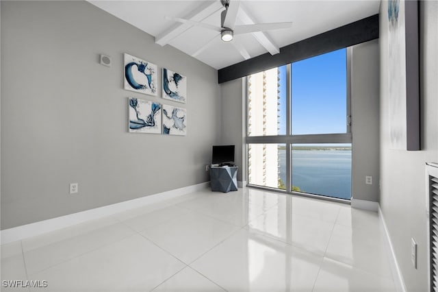 empty room featuring ceiling fan, tile patterned flooring, and beam ceiling