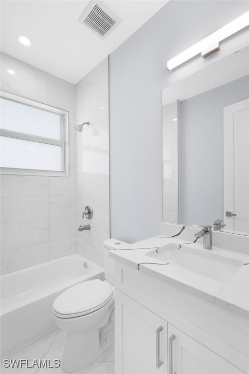 full bathroom with tiled shower / bath, vanity, and toilet