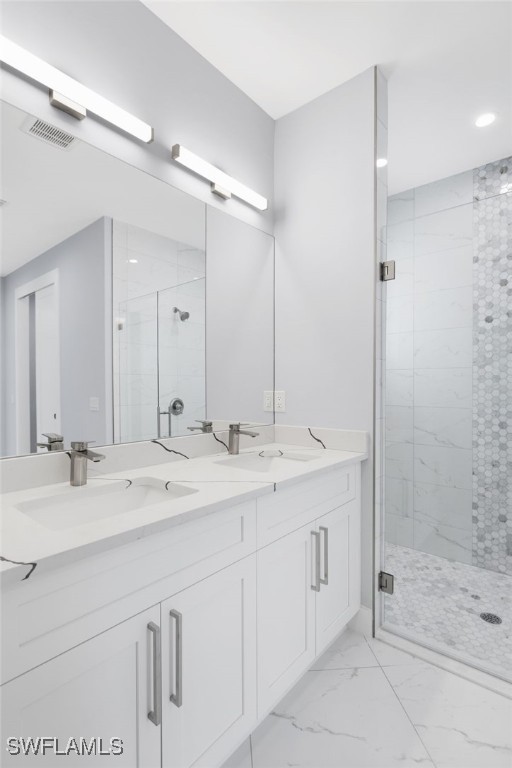 bathroom featuring a shower with door and vanity