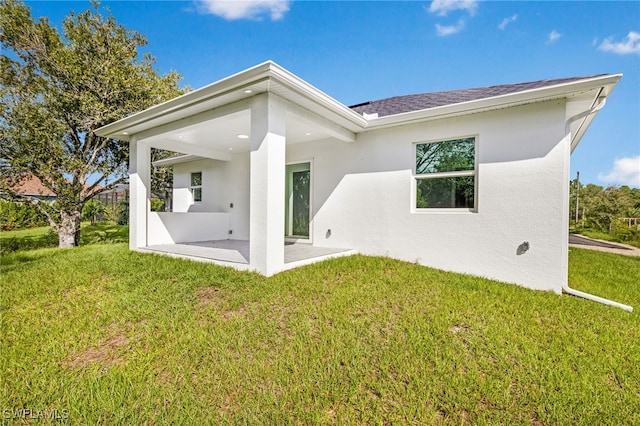 back of house with a patio and a yard