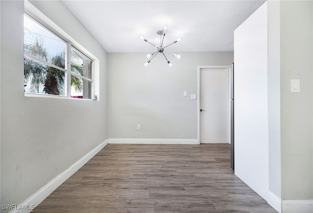 unfurnished room with a chandelier and hardwood / wood-style floors