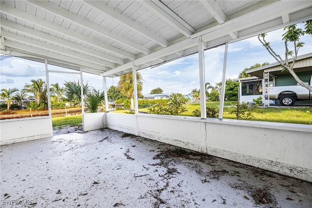 unfurnished sunroom with beam ceiling