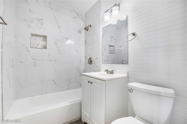 full bathroom featuring tiled shower / bath, vanity, and toilet