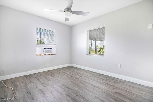 spare room with a healthy amount of sunlight, ceiling fan, light hardwood / wood-style flooring, and cooling unit