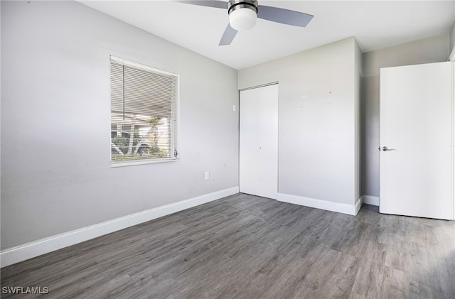 unfurnished bedroom featuring a closet, ceiling fan, and dark wood-type flooring