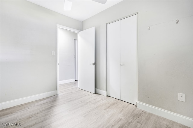 unfurnished bedroom with a closet, light wood-type flooring, and ceiling fan