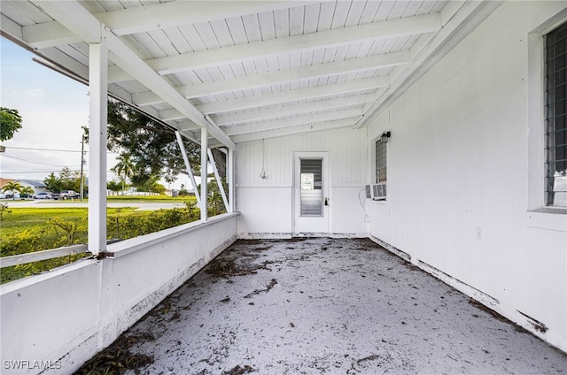 unfurnished sunroom with vaulted ceiling with beams and a wealth of natural light