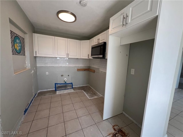 washroom with laundry area, hookup for a washing machine, baseboards, and light tile patterned floors