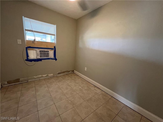 spare room with cooling unit, baseboards, and light tile patterned floors