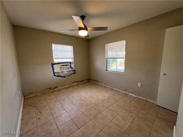 spare room featuring ceiling fan, light tile patterned floors, and cooling unit