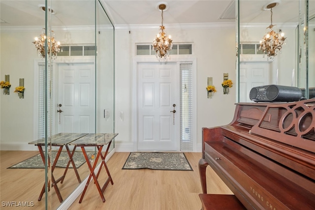 entrance foyer featuring an inviting chandelier, wood-type flooring, and crown molding