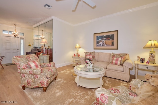 living room featuring ornamental molding, ceiling fan with notable chandelier, and light hardwood / wood-style floors