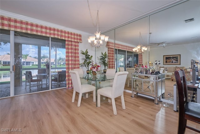 dining space with ceiling fan with notable chandelier, crown molding, and hardwood / wood-style floors